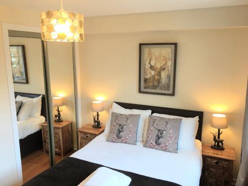1 dormitorio con 1 cama con sábanas y almohadas blancas en Grassmarket, Castle Wynd Apartment, en Edimburgo