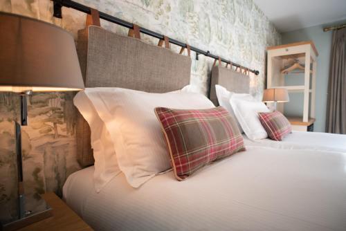 a bedroom with two beds with white pillows at Cromwell Arms Country Pub with Rooms in Romsey