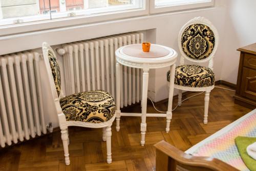 a room with two chairs and a table and radiator at Iancu Apartments in Bucharest