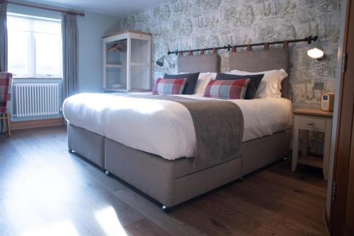 a bedroom with a large bed with pillows on it at Cromwell Arms Country Pub with Rooms in Romsey