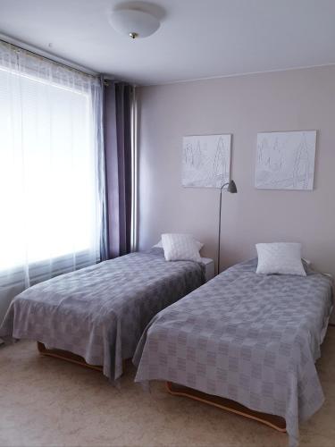 a bedroom with two beds and a window at Apartments N & P in Kotka