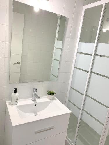 a white bathroom with a sink and a mirror at Apartamento 1ª Linea de Mar -WIFI- Aire Acondicionado in Empuriabrava