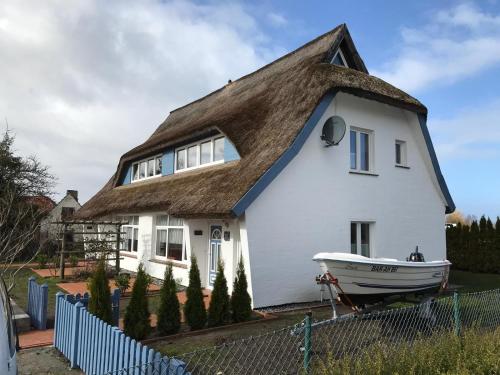 a house with a boat in front of it at Küstenhuus-Katy in Glowe