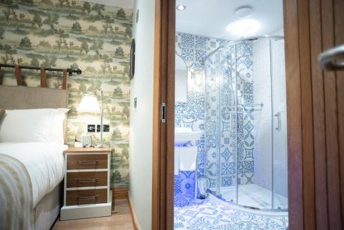 a bedroom with a shower and a bed at Cromwell Arms Country Pub with Rooms in Romsey