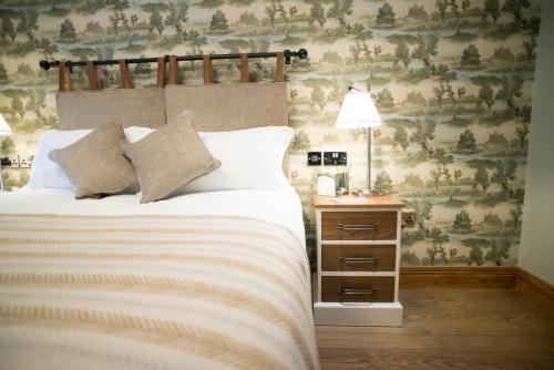 a bedroom with a bed and a table with a lamp at Cromwell Arms Country Pub with Rooms in Romsey