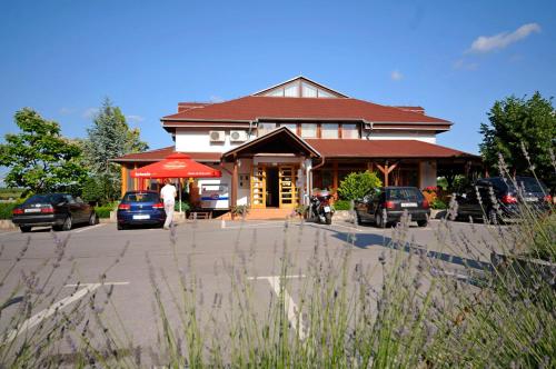 a building with cars parked in front of it at Plitvicka Vrela in Grabovac