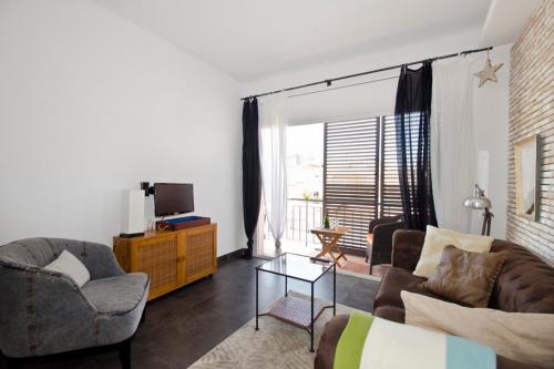 a living room with a couch and chairs and a tv at Cal Xillo in Torredembarra