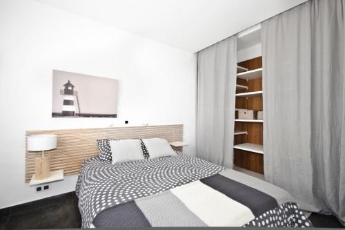 a white bedroom with a bed and a lighthouse at Cal Xillo in Torredembarra