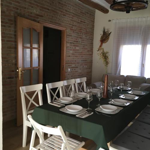 una sala da pranzo con tavolo e sedie verdi di La Manguita Bardenas ad Arguedas