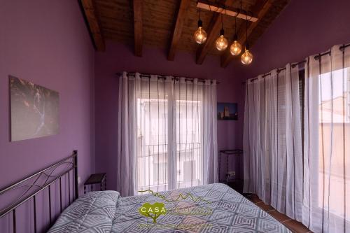 a bedroom with a bed and a large window at Casa Chaluca in La Aldehuela