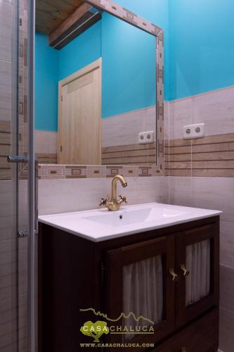 a bathroom with a sink and a mirror at Casa Chaluca in La Aldehuela