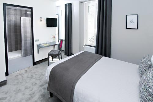 a hotel room with a large bed and a desk at Logis Hotel Restaurant Nougier in Saint-Étienne-de-Fursac
