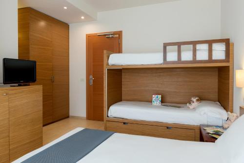a bedroom with two bunk beds and a television at Hotel Baltic in Giulianova