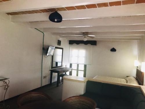 a living room with a ceiling fan and a table at Hotel La Mansión in San José Iturbide