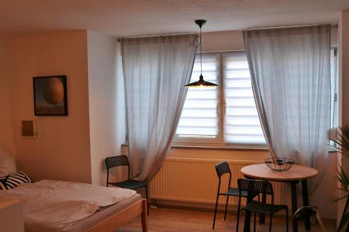 1 dormitorio con cama, mesa y ventana en Apartment No. 55 - 10 Min to city centre, en Leipzig