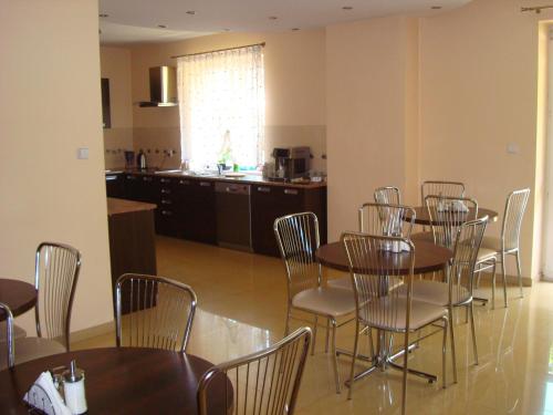 a dining room with tables and chairs and a kitchen at Villa Lena in Gdańsk