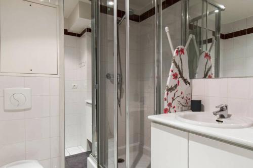 W łazience znajduje się prysznic i umywalka. w obiekcie Champs Elysees Flat w Paryżu