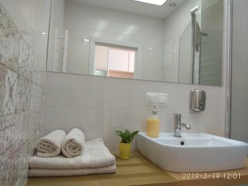 Baño blanco con lavabo y espejo en Simply the best, en Odessa