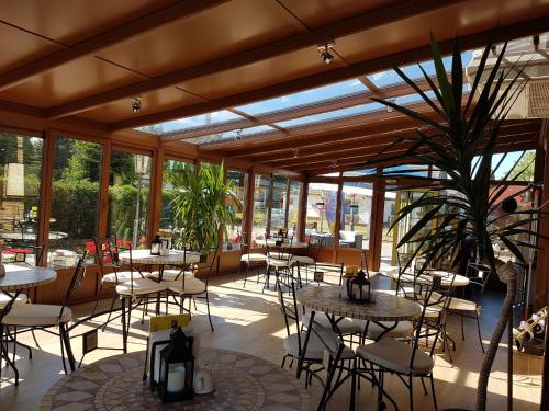 a restaurant with tables and chairs and windows at Klif Spa in Jarosławiec