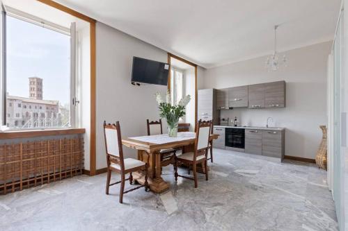 una sala da pranzo con tavolo e sedie e una cucina di View Colosseo From Jacuzzi a Roma