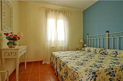a bedroom with a bed and a table and a window at Casa Rural La Sierra de Monfragüe in Malpartida de Plasencia