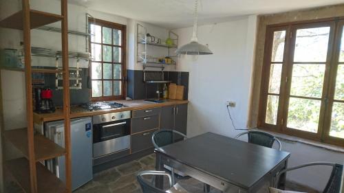 a kitchen with a table and a table and chairs at Volets rouges in Mons