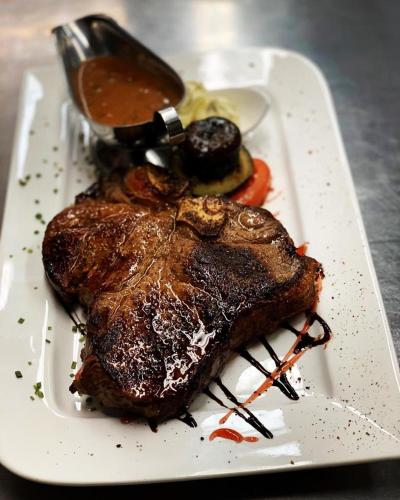 a white plate with a piece of steak and sauce at Ködnitzhof in Kals am Großglockner