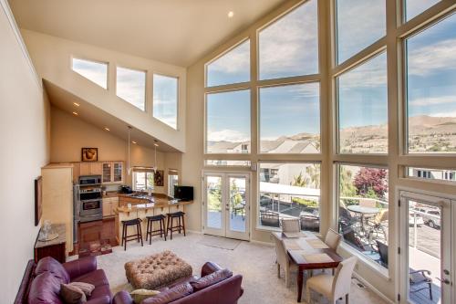 a large living room with large windows and a kitchen at Chelan Resort Waterfront Townhouse in Chelan