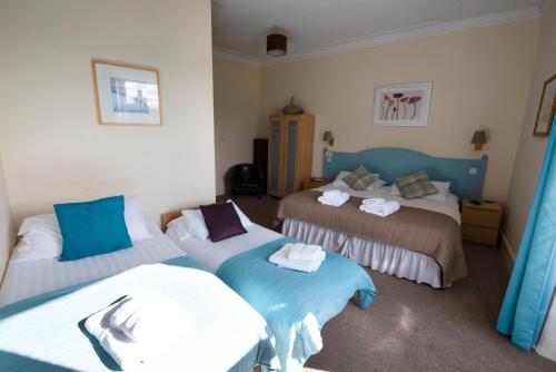 a bedroom with two beds with towels on them at The Kirkmichael Hotel in Kirkmichael