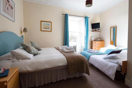 a bedroom with two beds and a window at The Kirkmichael Hotel in Kirkmichael