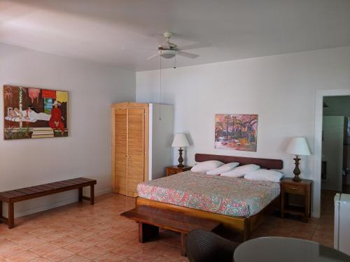 a bedroom with a bed and a table and a fan at La Sagesse Hotel, Restaurant and Beach Bar in Content