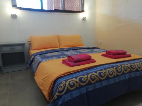 a bed with two red pillows on top of it at Oceanside Apartment in El Medano in El Médano