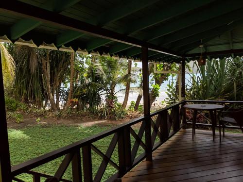 a wooden porch with a table on a deck at La Sagesse Hotel, Restaurant and Beach Bar in Content