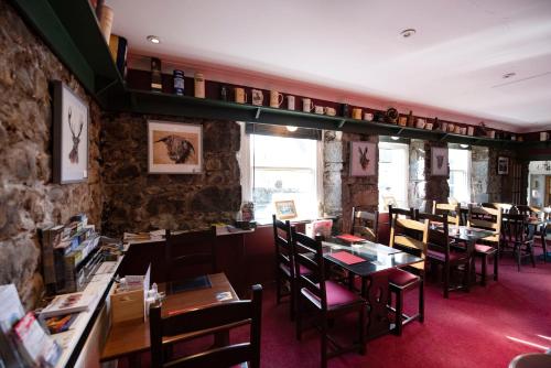 a dining room with tables and chairs in a restaurant at The Kirkmichael Hotel in Kirkmichael