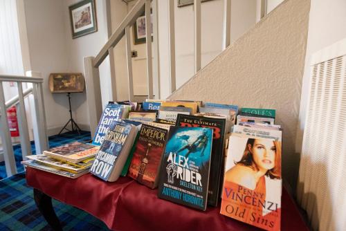 a table with a bunch of books on it at The Kirkmichael Hotel in Kirkmichael