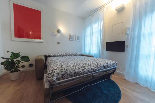ein Schlafzimmer mit einem Bett und einem großen Fenster in der Unterkunft Accogliente monolocale alla Gran Madre in Turin