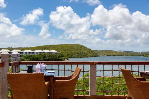 a patio area with chairs, tables and umbrellas at Escape at Nonsuch Bay Antigua - All Inclusive - Adults Only in Gaynors
