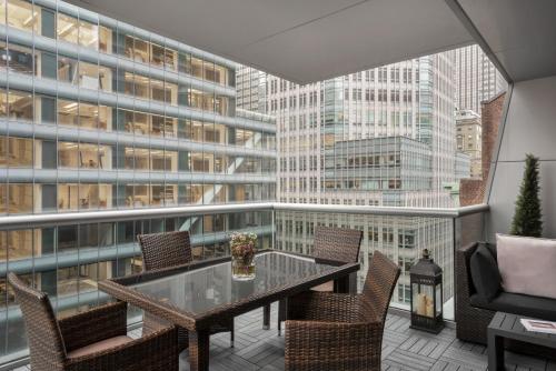 a balcony with a table and chairs and a large window at The Gotham Hotel in New York