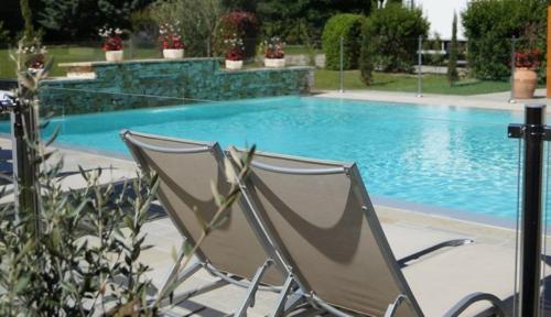 a chair sitting in front of a swimming pool at Hotel Restaurant La Martiniere in Montélier
