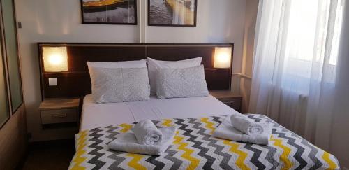 诺维萨德YELLOW FLOWER的一间卧室，床上有一张带毛巾的床