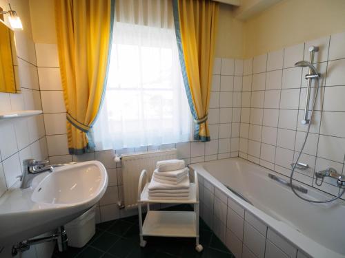 a bathroom with a tub and a sink and a bath tub at Aparthotel Alpina in Filzmoos