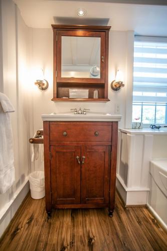 a bathroom with a sink and a mirror at Auberge Seigneurie des Monts in Sainte-Anne-des-Monts