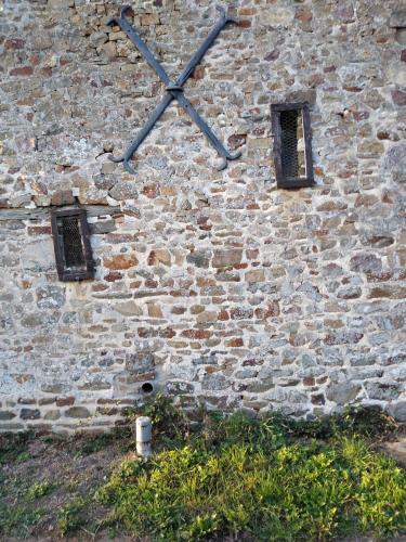 a clock on the side of a brick wall at Gite Rouge and la Ferme Blanche in MÃ©nil-Vin