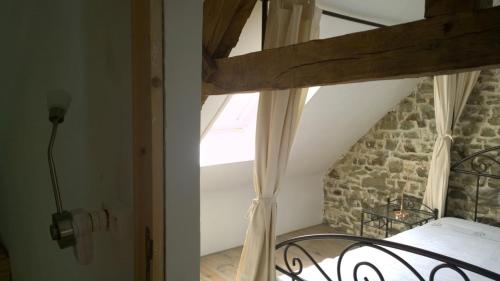 a bedroom with a bed and a stone wall at Gite Rouge and la Ferme Blanche in MÃ©nil-Vin