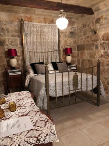 Mġarr的住宿－Ta Skorba Farmhouse Mgarr，一间卧室配有一张床、两张桌子和两盏灯。