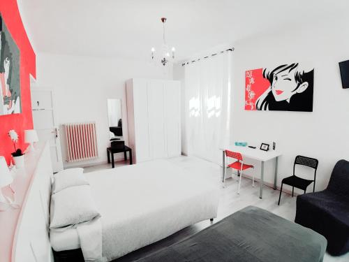 Habitación blanca con cama y escritorio. en B&B Lupin Trento, en Trento