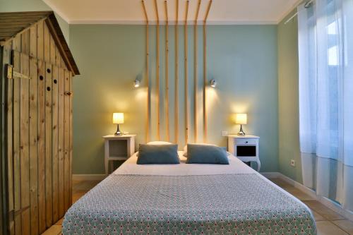 a bedroom with a large bed with blue pillows at Hôtel La Bastide in Hyères
