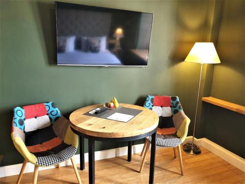 a room with a table and two chairs and a lamp at SleepWell Apartments Ordynacka in Warsaw