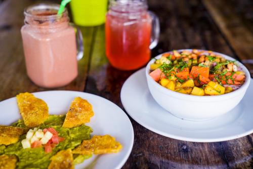 a table with two plates of food and a bowl of salad at Nílu Cancun Zona Hotelera by Selina in Cancún