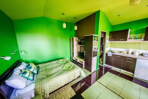 une chambre verte avec un lit et une cuisine dans l'établissement VIP Green House of Hope for 2, à Leliūnai